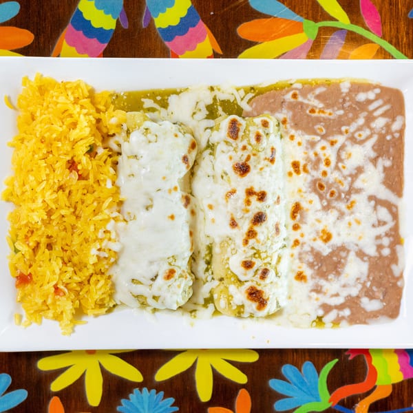 Three cheesy green enchiladas with yellow rice and refried beans on a white plate.